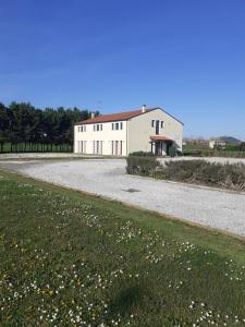 a large white barn with a gravel driveway at Temporin Ospitalità in Monselice