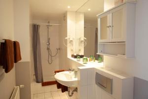 a white bathroom with a sink and a shower at Altstadtfreude Stralsund in Stralsund +35 photos