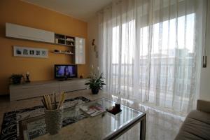 sala de estar con mesa de cristal y ventana grande en House Navigli, en Milán