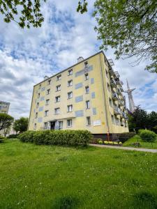 a large yellow building with a windmill in the background at Robotnicza 59 Old Town Apartment in Elblag