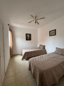 a bedroom with two beds and a ceiling fan at Duplex Los Molles in Santa Rosa