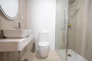 a bathroom with a toilet and a sink and a shower at Casa da Tia Clementina in Santana +37 photos