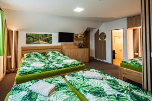 a bedroom with two beds and a flat screen tv at Vinný sklep u Křížů in Milotice