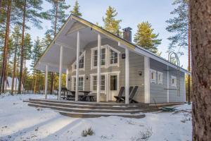 a house in the woods with snow on the ground at Villa Alex in Virttaa