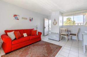 a living room with a red couch and a table at Sea Palm G in Fort Walton Beach
