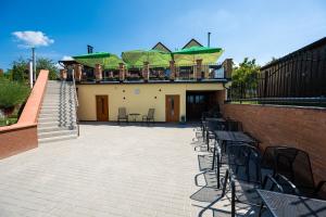 a patio with chairs and tables and a building at Vinný sklep u Křížů in Milotice
