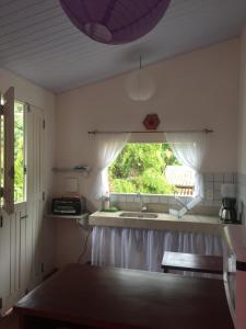 a kitchen with a sink and a window at Cantinho da Fabi in Pipa
