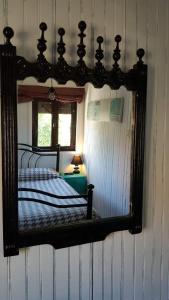 a mirror on the wall of a bedroom at Casa Urgueira in Pendilhe