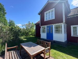 a picnic table and bench in front of a house at Hus Hagagatan in Ruda