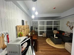 a living room with a couch and a tv at Mi Casa in Tagaytay