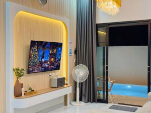 a living room with a tv on a wall at Jaegun Pool VIlla Aonang in Ao Nam Mao