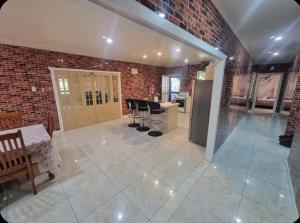 a kitchen and a living room with a brick wall at Dream Big Accommodation in Apia