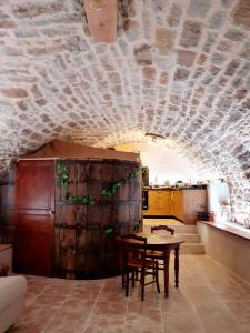 a dining room with a table and a stone wall at Studio l'envoûté in Saint-Rome-de-Tarn