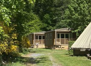 a row of camping cottages in the woods at Camping Le Canada-Insolite in Chiny
