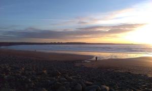 a beach with a person standing on the beach at Cluain Uilinn in Miltown Malbay