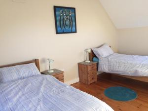 a bedroom with two beds and a mirror on the wall at Cluain Uilinn in Milltown Malbay