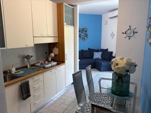 a kitchen with a table and a blue couch at Lightblue in Marina di Massa +20 photos