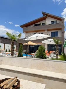 a resort with a swimming pool with chairs and umbrellas at Davos Hotel in Pʼarakʼar