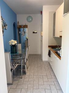 a kitchen with a table and chairs and a clock on the wall at Lightblue in Marina di Massa