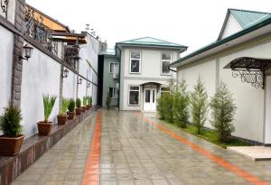 an empty courtyard with potted plants and a white building at Carat Hotel in Tashkent