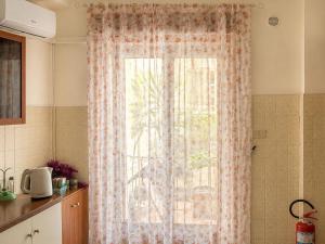 a window with a curtain in a kitchen at Vista Isole Eolie in Piraino