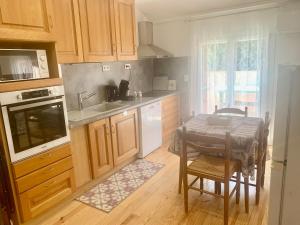 a kitchen with wooden cabinets and a table and a sink at Chez Pierre in Le Val