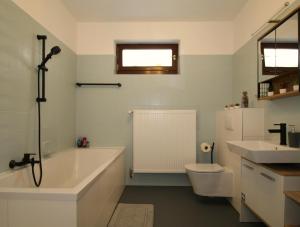 a bathroom with a tub and a toilet and a sink at Weiher Apartment mit Terrasse & Parkplatz in Kulmbach +14 photos