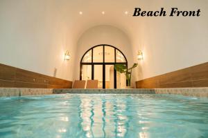 a swimming pool in a building with a large window at Théo Privé Kohlarn in Ko Lan