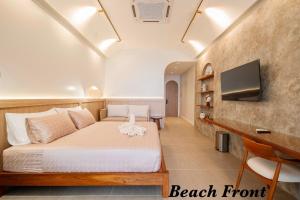 a bedroom with a bed and a desk and a television at Théo Privé Kohlarn in Ko Lan