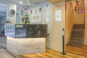a lobby with a marble counter and a staircase at Collection O Royce Studios Near Pune Airport in Pune