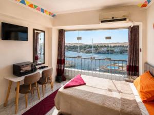 a room with a bed and a window with a view at NubaNest GuestHouse in Aswan