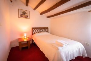 a bedroom with a white bed and a table with a candle at Casa Rural Mas Halcón in Useras +27 photos
