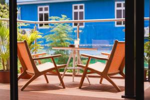 a table and two chairs on a deck with a table and chairs at Island Ufaa Dharavandhoo in Dharavandhoo