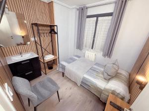 a small bedroom with a bed and a sink at PENSIÓN PESQUERO in Burgos