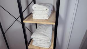 a stack of towels on a wooden shelf at PENSIÓN PESQUERO in Burgos
