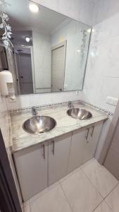a bathroom with two sinks and a large mirror at PENSIÓN PESQUERO in Burgos