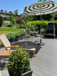 a patio with an umbrella and chairs and a table at inHome Vista Murten in Murten