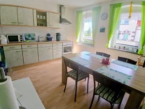 a kitchen with a table and chairs in a room at Ferienwohnung-Heidi in Neuwilthen