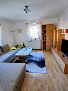 a living room with a couch and a table at Ferienwohnung-Heidi in Neuwilthen