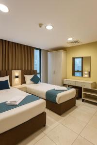 a hotel room with two beds and a desk at Al Amer Palace Hotel in Amman