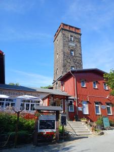 a red barn with a tall tower on top of it at Ferienwohnung-Heidi in Neuwilthen