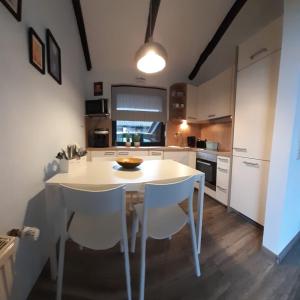 a kitchen with a white table and white chairs at Haus am Meer Eckwarden in Butjadingen