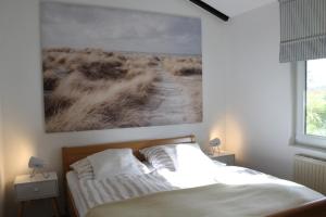 a bedroom with a bed and a painting on the wall at Haus am Meer Eckwarden in Butjadingen