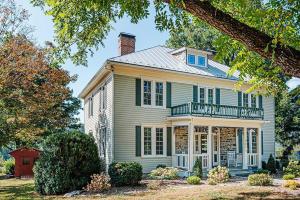 a large white house with a porch and a chimney at Clonmel Acres in Afton