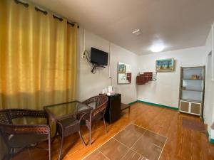 a living room with a table and chairs and a television at Patcharin Home Stay in Ko Yao Yai