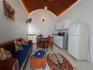 a living room with a couch and a table and a refrigerator at Nefertiti Guest House in ‘Ezbet Abu Ḥabashi