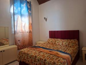 a bedroom with a bed and a window with a curtain at Nefertiti Guest House in ‘Ezbet Abu Ḥabashi +82 photos