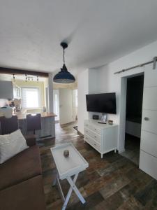 a living room with a couch and a tv and a table at Ferienwohnung Am See 55 in Bad Saarow