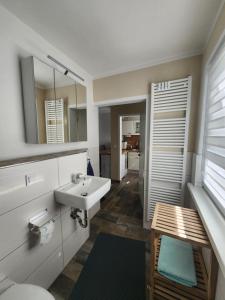 a bathroom with a sink and a mirror at Ferienwohnung Am See 55 in Bad Saarow +14 photos