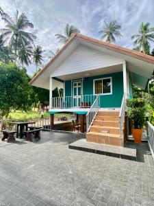 a small blue house with a porch and stairs at Patcharin Home Stay in Ko Yao Yai